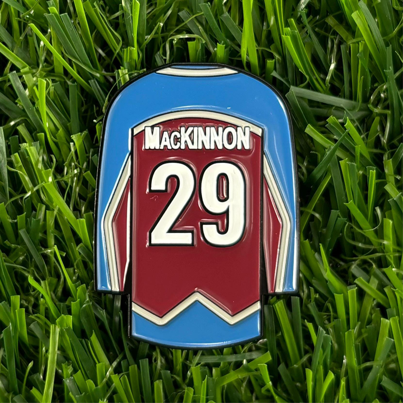 Nathan MacKinnon jersey-inspired golf ball marker on grass, sports ball marker for golfers