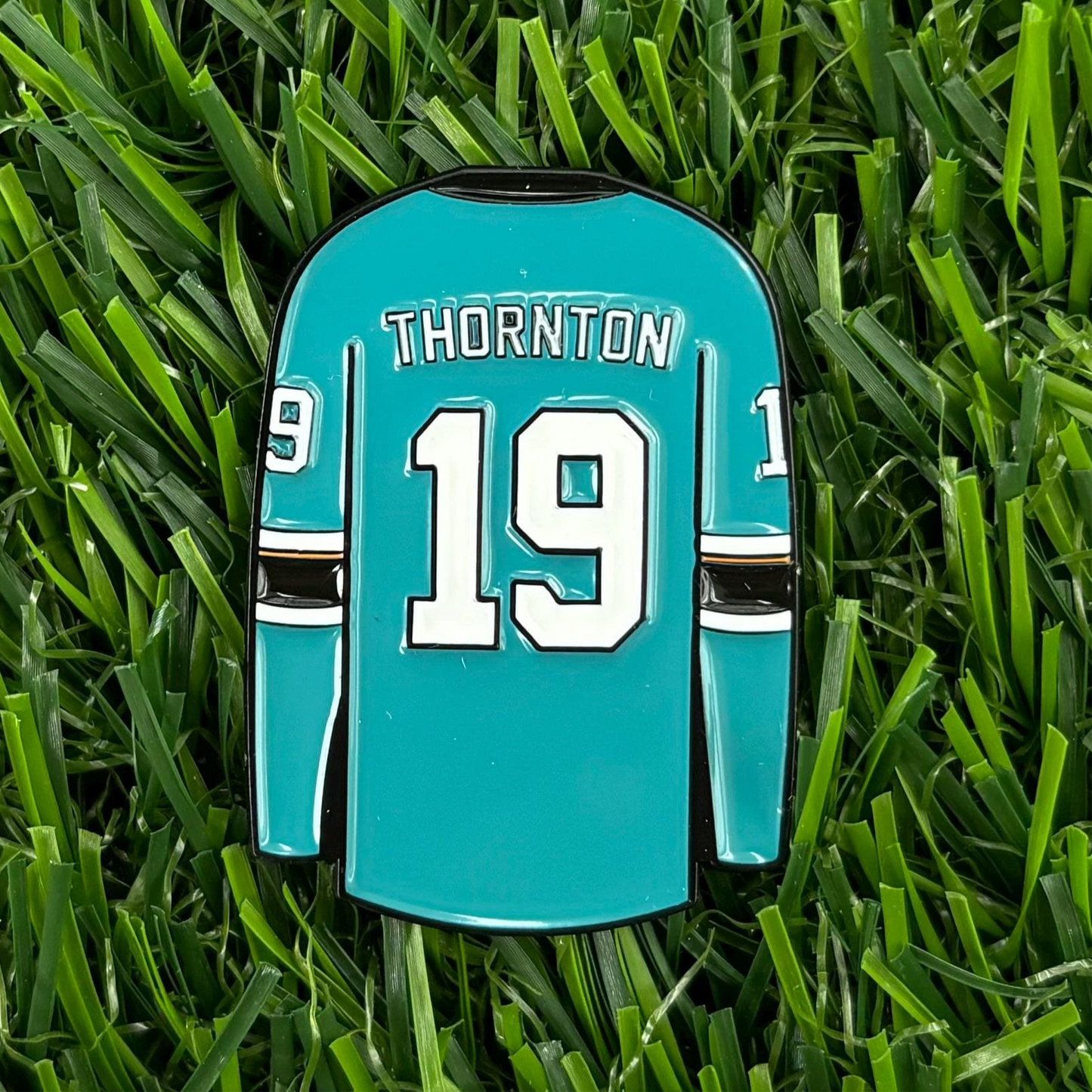 Joe Thornton custom hockey jersey golf ball marker on grass, personalized and high-quality accessory for golf enthusiasts.