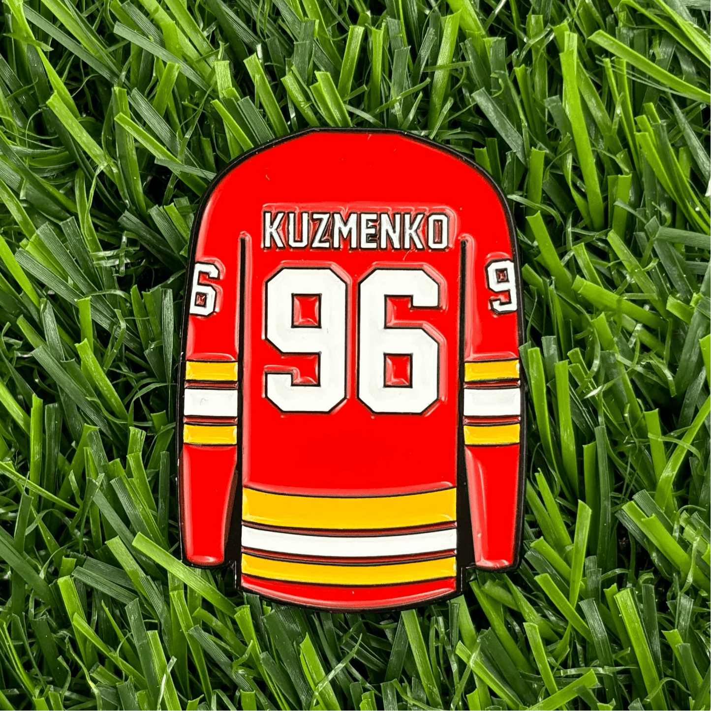 Andrei Kuzmenko red jersey golf ball marker on grass background