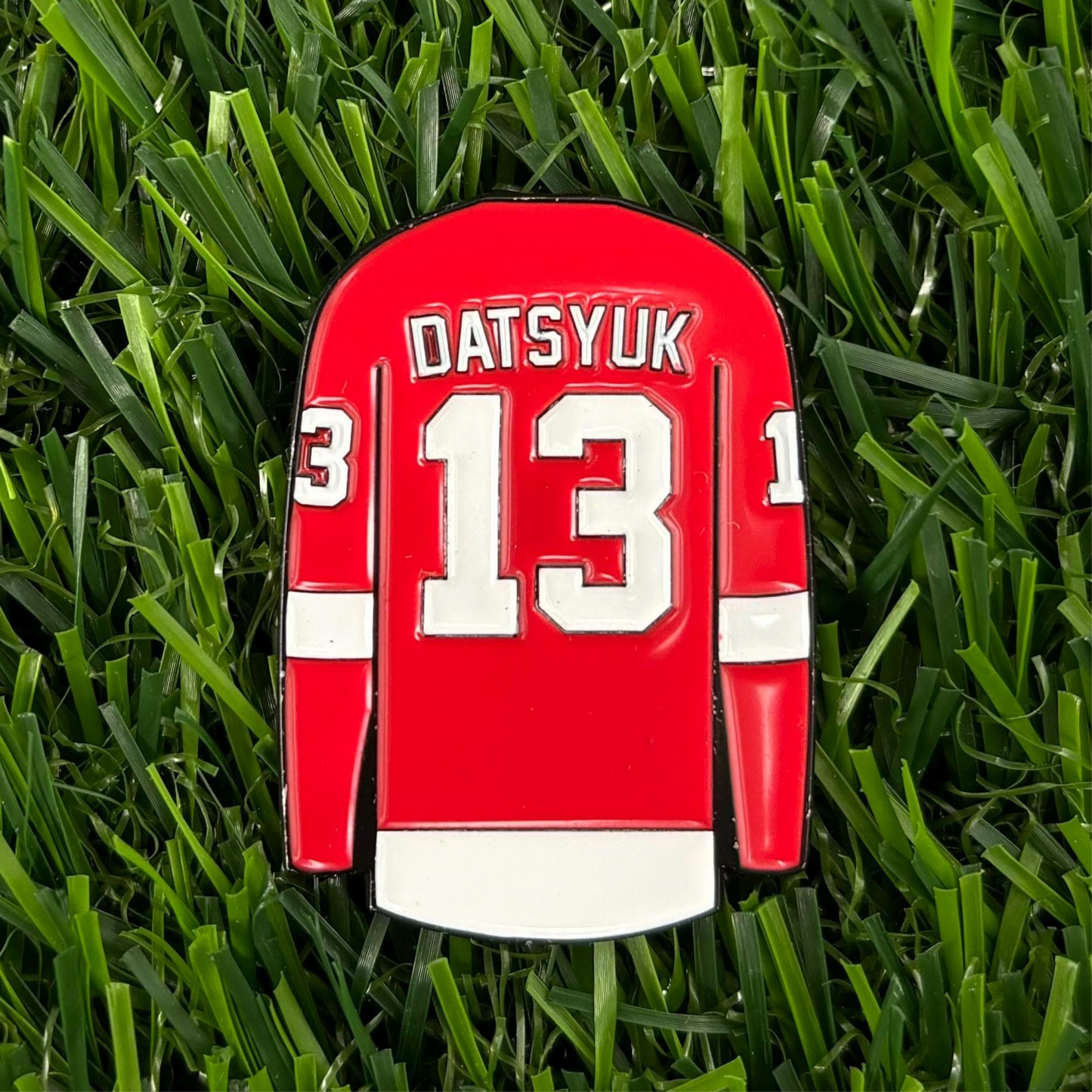 Pavel Datsyuk golf ball marker featuring red jersey design with jersey number 13 on grass