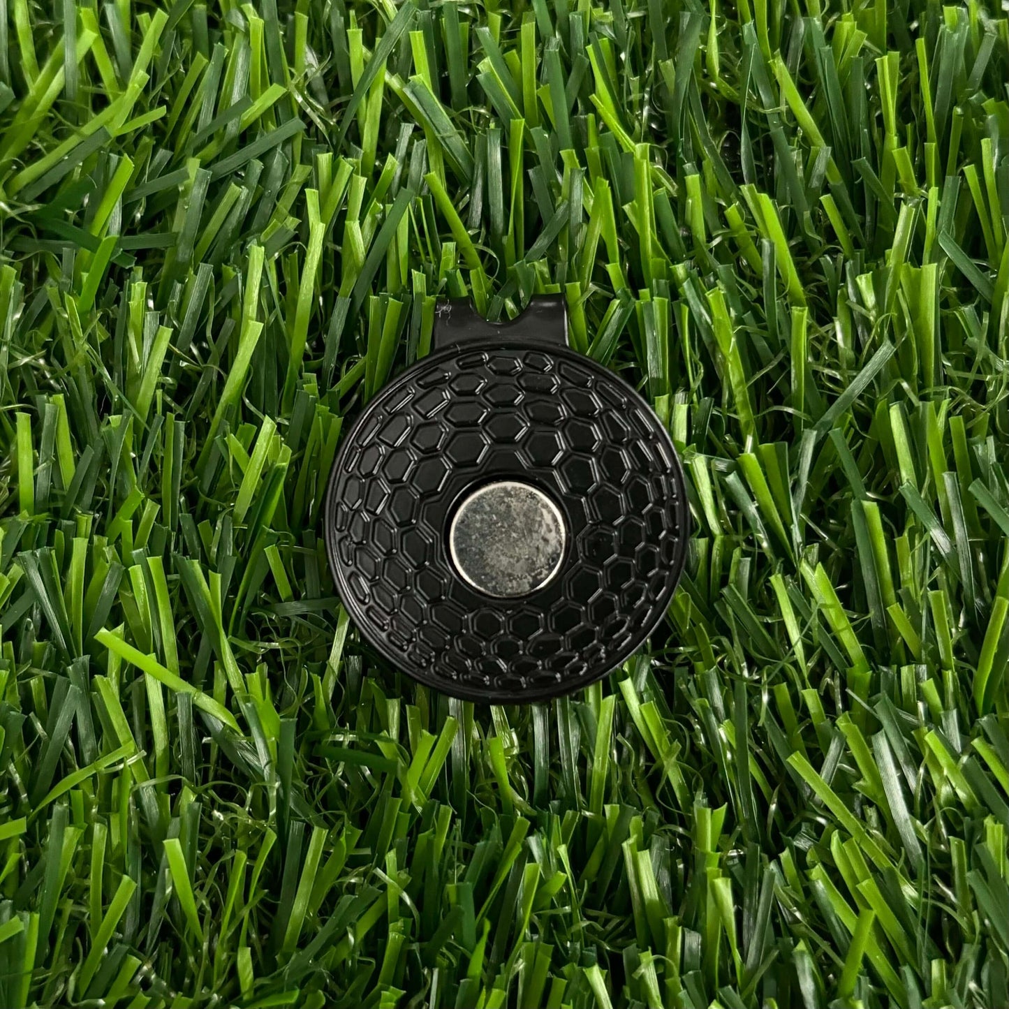 Andrei Kuzmenko golf ball marker on green grass, stylish and durable golf accessory for enthusiasts and collectors