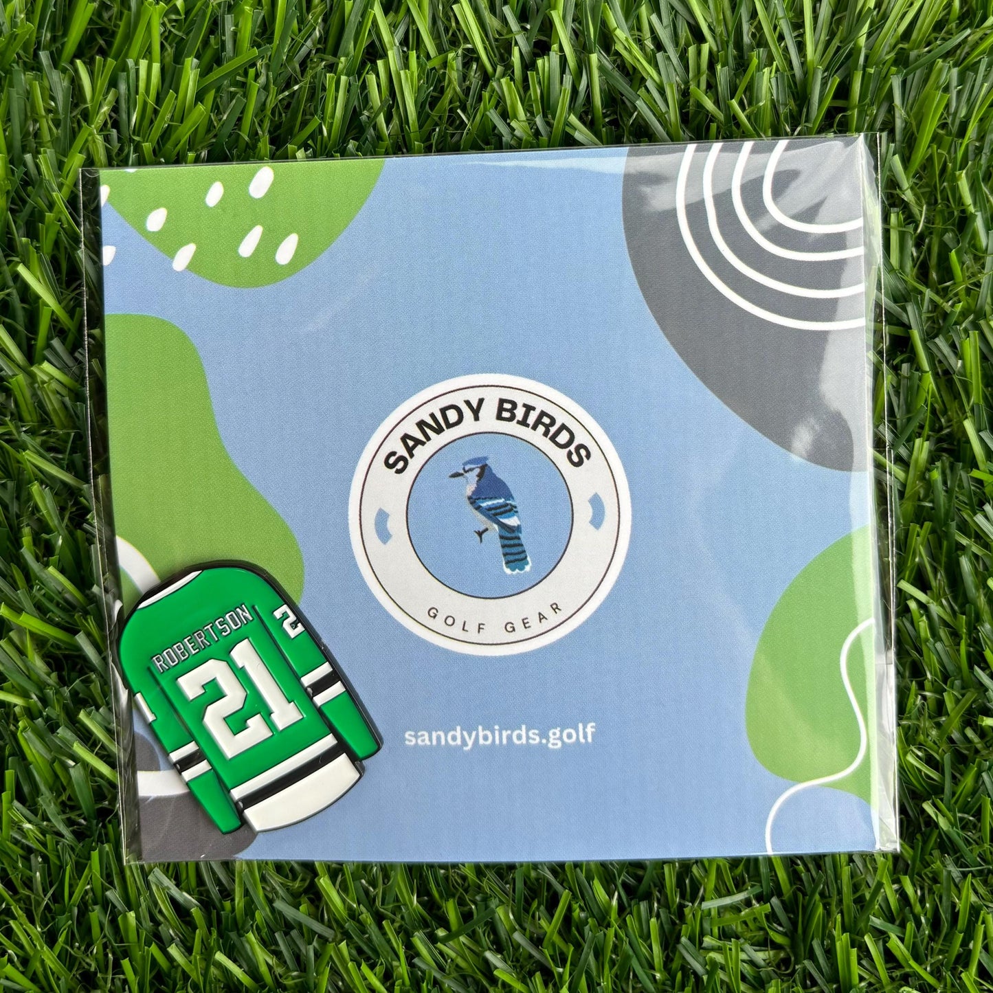 Jason Robertson personalized golf ball marker by Sandy Birds on green grass with stylish packaging.