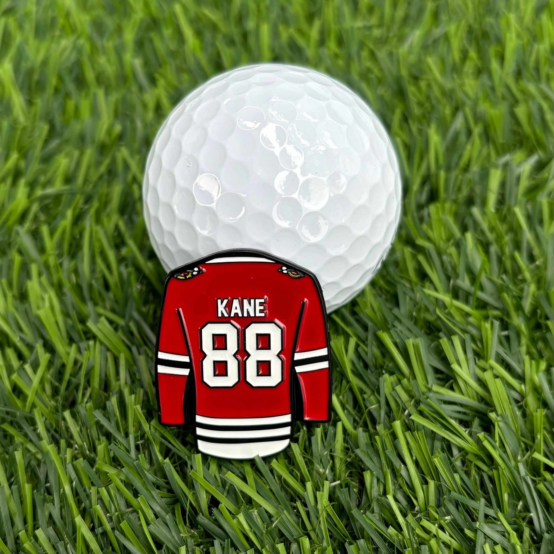 Patrick Kane custom golf ball marker featuring jersey design on grass beside a golf ball