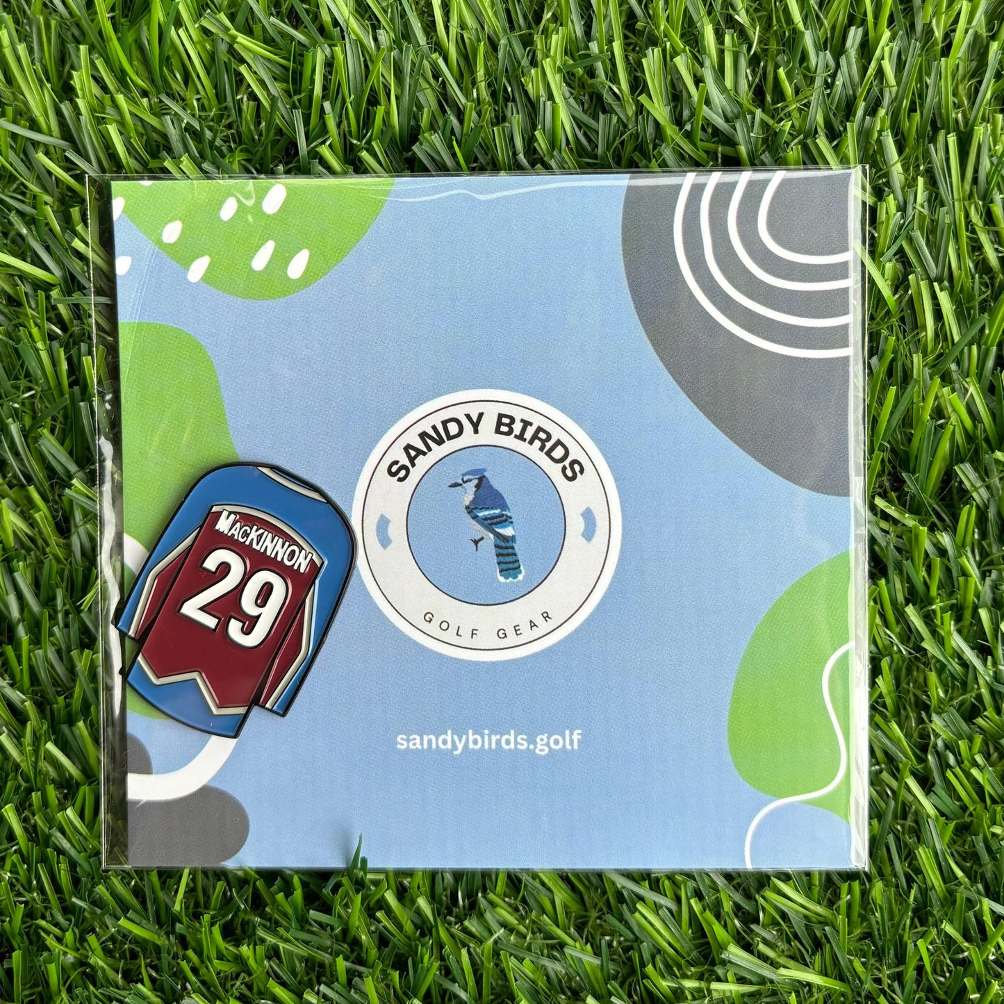 Nathan MacKinnon custom golf ball marker by Sandy Birds on packaging with grassy background